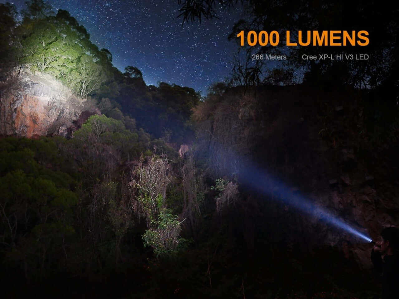 Fenix UC35 V2.0 flashlight illuminating rocky terrain at night, showcasing 1000 lumens and 266 meters distance.