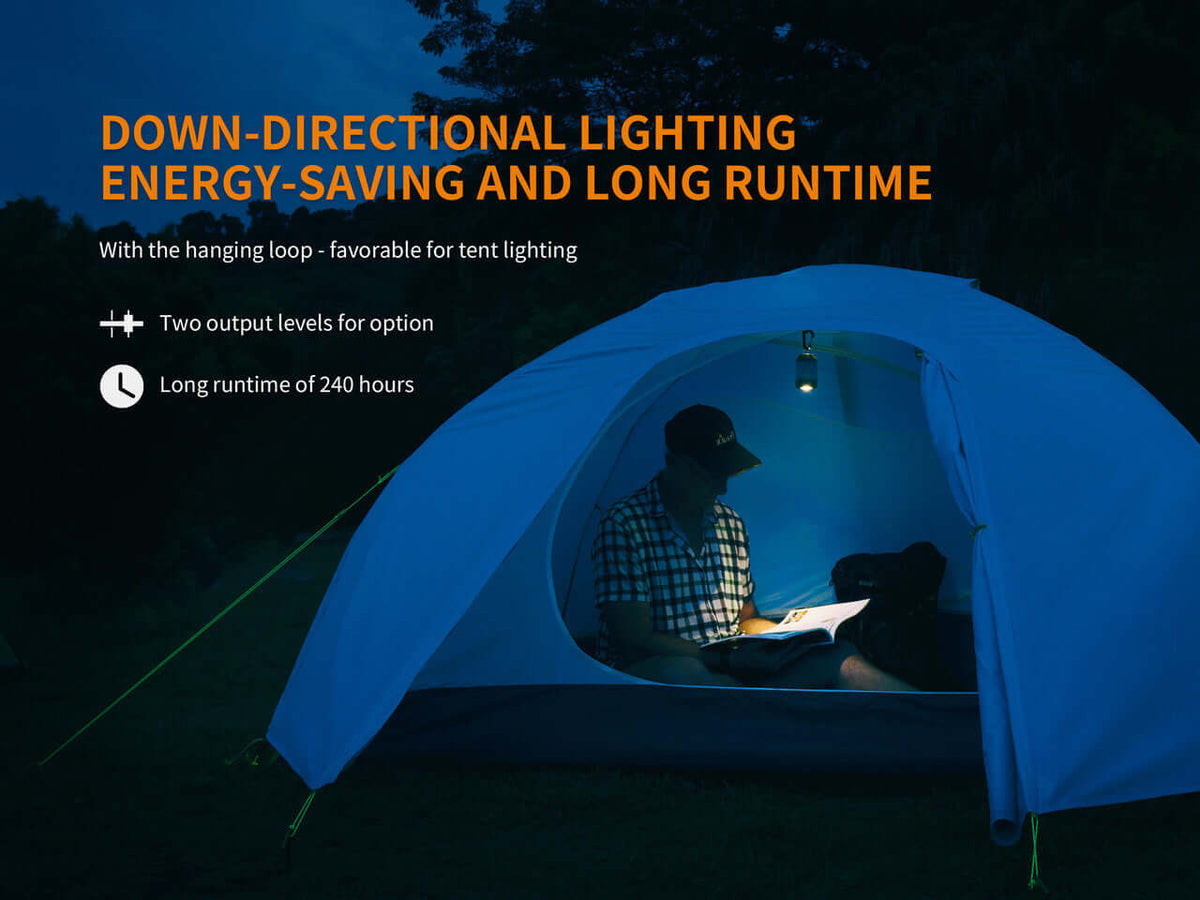 Person reading inside a tent illuminated by the Fenix CL26R camping lantern, showcasing energy-saving features.